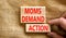 Moms demand action symbol. Concept words Moms demand action on wooden blocks on a beautiful canvas table canvas background.