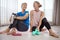 Moms in love with fitness. Portrait of two women taking a break while exercising together at home.