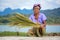 Mon ethnic woman separates seeds from rice plant
