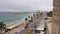 Monastir, Tunisia - 07 June 2018: Car traffic on city road along sea embankment. Palm trees on sea shore on background