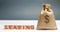 Money bag and blocks with the word Leasing. A lease is a contractual arrangement calling for the lessee to pay the lessor for use