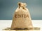 Money bag with the word Ebitda. Earnings before interest, taxes, depreciation and amortization. Financial result of the company.
