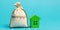 Money bag with the word Mortgage and wooden house. The accumulation of money to pay interest rates on mortgages. Buying a property