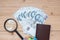 Money banknote with Passport, Magnifying glass, globe on wooden table, Top view and copy space. Time to Travel in Singapore