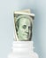 Money Bills in white pill bottle on blue background. medical concept