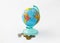 A money box made in the form of a globe, the planet Earth with a money slot at the top stands near to several coins, on a
