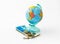 A money box made in the form of a globe, the planet Earth with a money slot at the top stands on a stack of Israeli banknotes of d