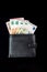 Money euro notes stick out from a black wallet on a black background. 5, 10, 50 euros. Vertical orientation.