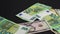 Money falling on table. Dropping lot of Euro and dollars paper banknotes on black background