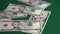 Money falling on table. Dropping lot of five ten twenty dollars paper banknotes on green background