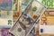 Money and finances concept. One hundred dollar new bill on colorful abstract background of Ukrainian, American and euro national