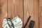 Money, glasses and car key on wooden table