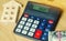Money and houses on the table and a calculator with the word Debt. The concept of buying property in debt. Analysis of costs and