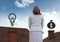 Money and light bulb icons and Businesswoman standing on Roofs with chimney and and blue sky