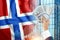 Money in a man`s hand against the background of the flag of Norway. Norwegians` income. Financial condition of residents of Norw