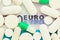 Money pills. Medicine pills on euro bills on a blue background. Covid-19 coronavirus pills are in euro money. The