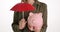 Money protection concept with umbrella over piglet