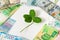 Money and shamrock. Four leaf clover among euro, dollar and ruble banknotes on white background. Wealth, success, business, lucky