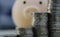 money stack with blurred piggy bank background conceptual for business finance