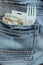 Moneys, card key and fork in a pocket of blue jeans of the employee hurrying on a lunch break close-up. the concept of fast food