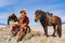 Mongolian Golden Eagle Hunter with his horse and a well trained golden eagle sat on the top of the mountain