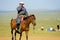 Mongolian Man Riding Horse Using Mobile Phone