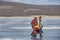 mongolian men in traditional clothing walking on frozen lake Khovsgol