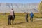 Mongolian nomads look at tourists whose motorcycle is broken