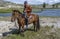 Mongolian Shepherd on Horseback near River