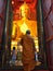 Monk enters the room with the Buddha statue Luang Pho Tho