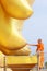 A monk saying prayer at the fingers of Big Golden Buddha Image at Wat Muang