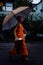 Monk during their early morning round around the town to collect their alms with umbrella