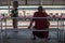 A monk waiting on a bench by the Yangon circular train station, Myanmar