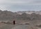 Monk walking on the barren road near Leh, Ladakh, India