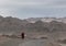 Monk walking on the barren road near Leh, Ladakh, India,