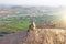 A monkey with a black face or snout sits on top of a mountain in India, Hampi, on Mount Hanuman