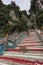 Monkey on the stairs leading up to the Batu Caves entrance in Kuala Lumpur Malaysia. Batu Caves are located just north of Kuala Lu