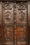 Monks, priests and symbols on wooden door inside gothic style 12th century Saint Michael`s church