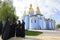 Monks standing near the church, St. Michael Golden-Domed Monastery on a background. April 27, 2018. Kiev, Ukraine