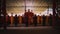 The monks standing and praying in front of the red altar while wearing an orange robe