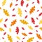 Mono print style scattered leaves seamless vector pattern background. Textured cut out yellow, red, orange foliage on