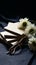 Monochromatic elegance Stack of envelopes, eyeglass, and flower on black