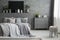 Monochromatic grey bedroom interior with a big bed with throws a