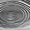 A monochromatic image of a single droplet of water creating ripples in a still pool, capturing a moment of tranquility4, Generat