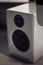 Monochrome close up of a white piano lacquer desktop speaker