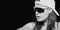 Monochrome closeup of the face of a sporty attractive woman with modern shades or sunglasses and peaked cap with wet long hair in