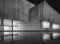 monochrome illustration of a large stained concrete brutalist building at night reflected in water.