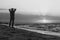 Monochrome image of man at sunrise on beach