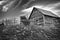 Monochrome Image of an Old, Dilapidated Homestead Under Cloudy Skies