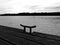 Monochrome perspective of wooden deck along a river shore with steel clit